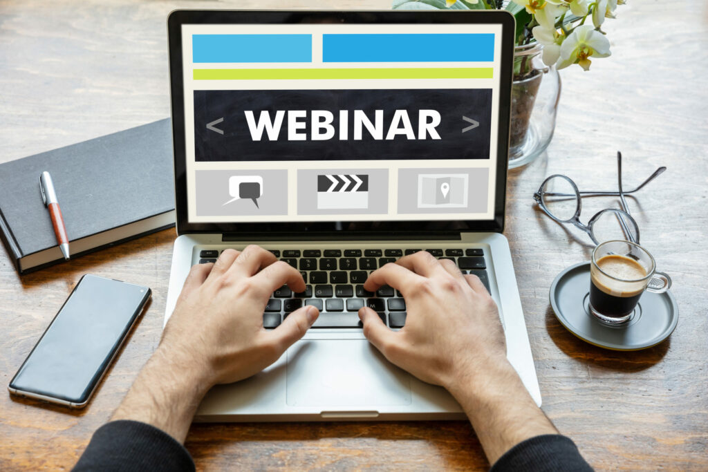 Webinar, online training and education, distance learning concept. Back view of a man working with a computer laptop, webinar text on the screen
